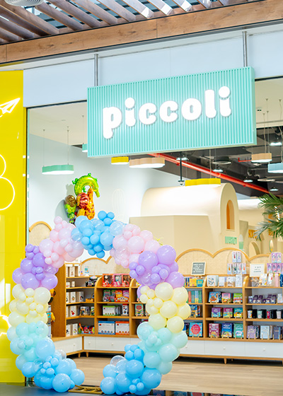 Piccoli indoor play center entrance at Avenue Mall with pastel balloon arch and storefront display.