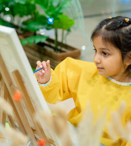Child painting during creative workshop session at Piccoli kids activity center.