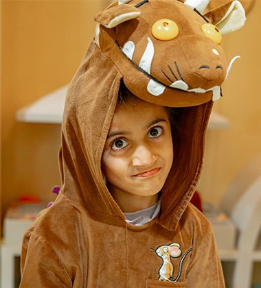 Child wearing a brown animal costume during themed play workshop at Piccoli indoor play area.