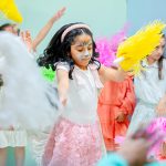 Children enjoying a themed celebration with costumes and colorful pom-poms at Piccoli birthday party.