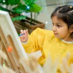 Child painting during creative workshop session at Piccoli kids activity center.