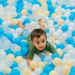 Toddler enjoying supervised ball pit play at Piccoli indoor play area.