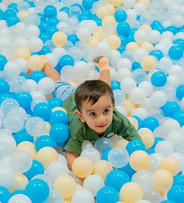 Toddler enjoying supervised ball pit play at Piccoli indoor play area.